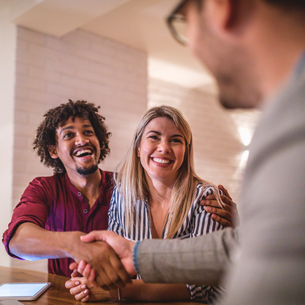 couple shaking hands with realtor